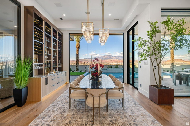 2867 East Granite Way St. George, UT 84790 - Photo 12 of 69 Spacious dining area featuring wood-finish flooring, a full-height built-in wine storage system, and two contemporary chandeliers
