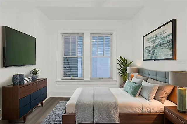 a view of a big room with wooden floor and windows