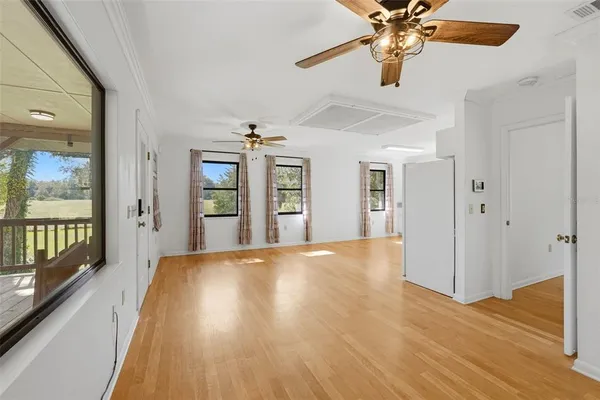 a view of an empty room with window and wooden floor