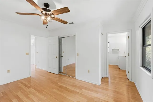 a view of a big room with wooden floor and a ceiling fan