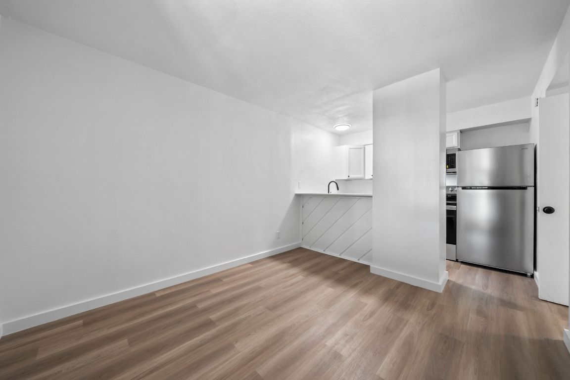 a view of empty room with wooden floor