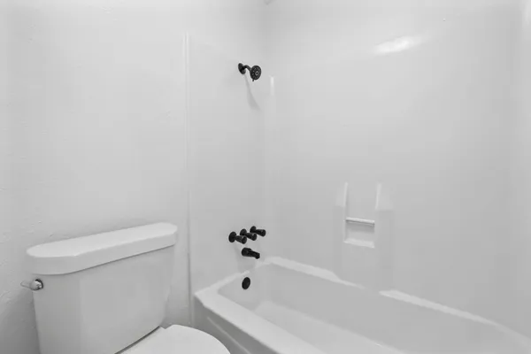 a white bath tub sitting next to a white toilet