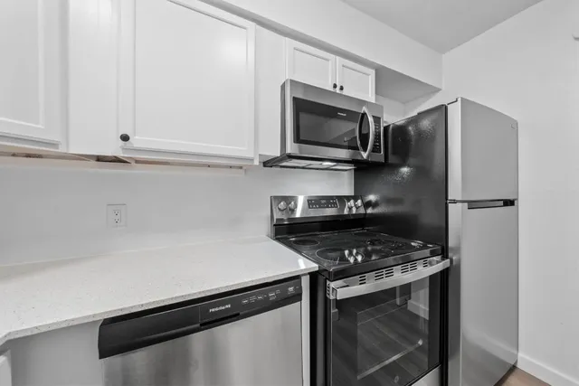 a kitchen with stainless steel appliances a stove microwave and sink
