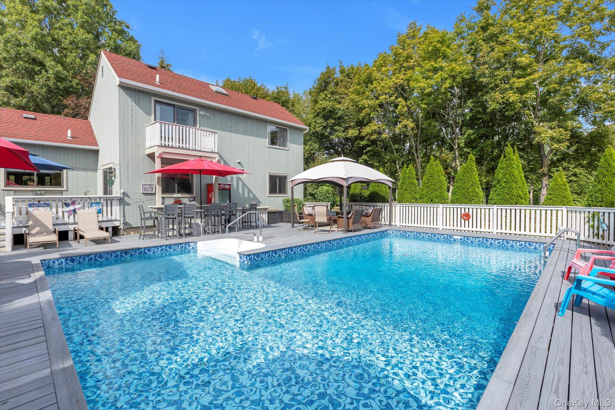 a swimming pool view with a seating space and a garden view