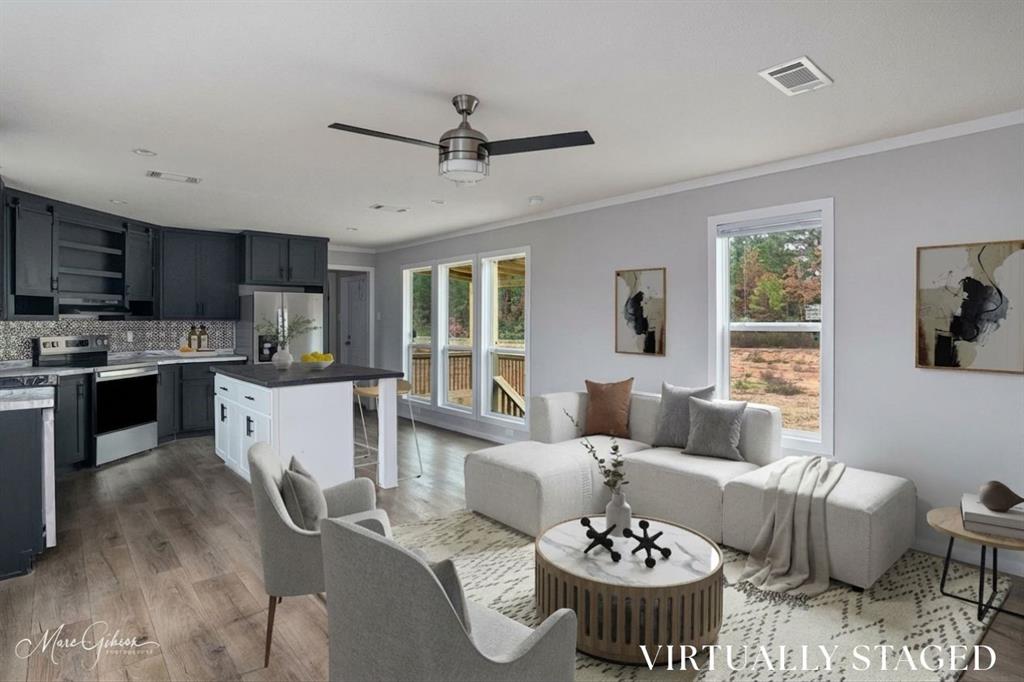 a living room with furniture and a dining table with kitchen view