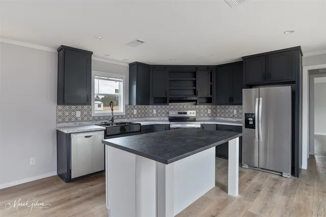 a kitchen with stainless steel appliances granite countertop a sink stove microwave and refrigerator