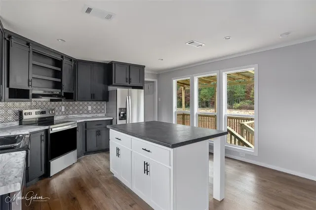 a kitchen with stainless steel appliances granite countertop a stove a sink and a refrigerator