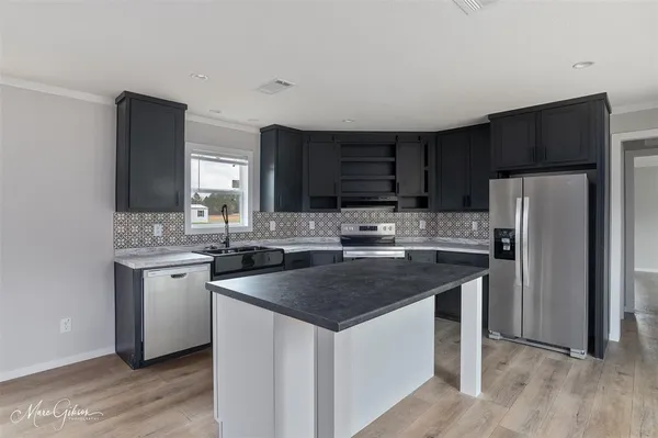 a kitchen with stainless steel appliances granite countertop a sink stove microwave and refrigerator