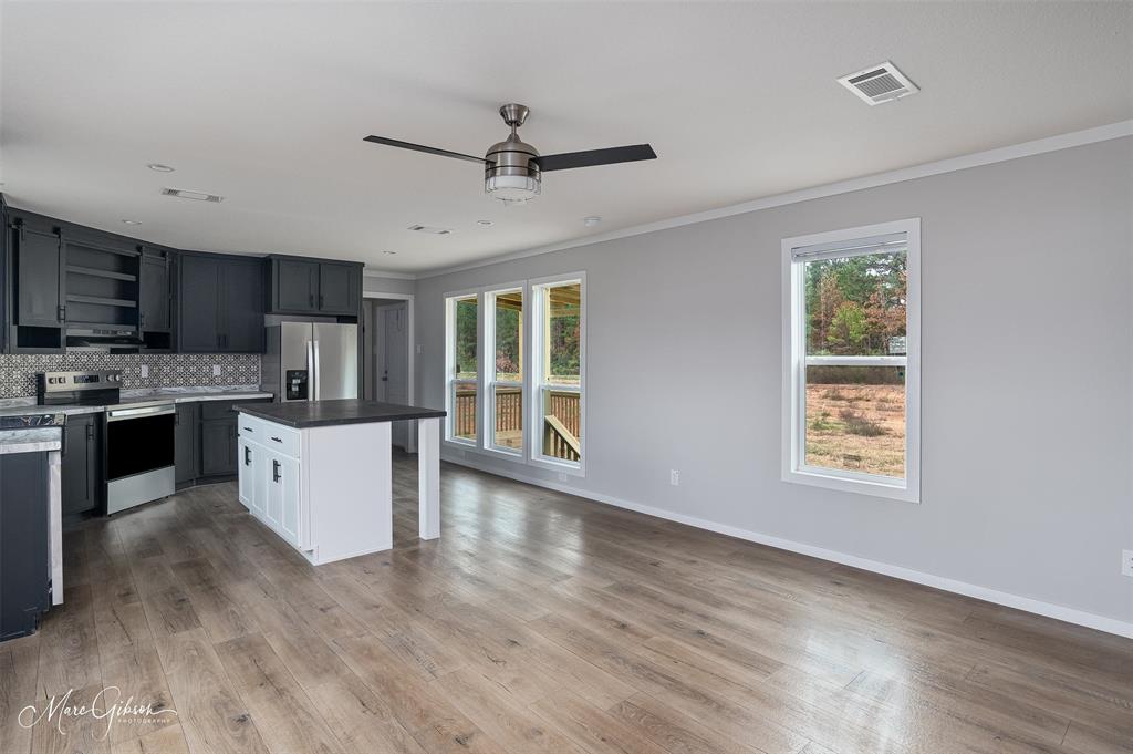 607 Nettleton Drive Princeton, LA 71067 - Photo 5 of 16 a large kitchen with stainless steel appliances granite countertop a stove a sink dishwasher a microwave oven with cabinets and wooden floor