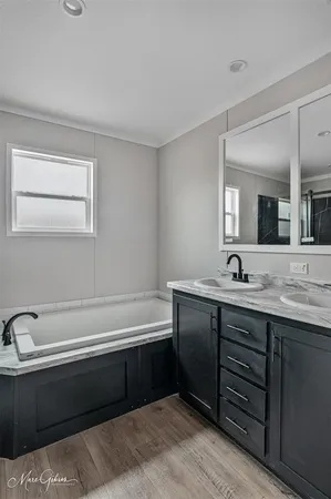 a bathroom with a tub sink and mirror