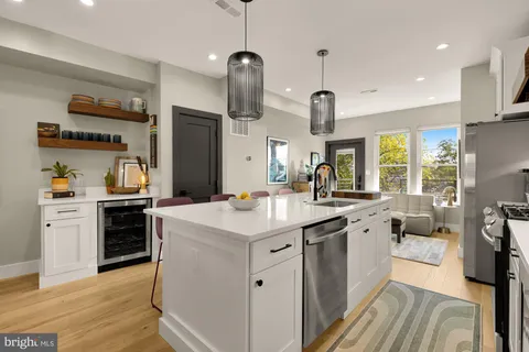 a kitchen with white cabinets appliances and wooden floor