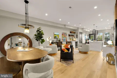 a living room with furniture a table and kitchen view