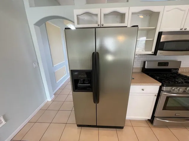 a kitchen with stainless steel appliances granite countertop a refrigerator and a stove