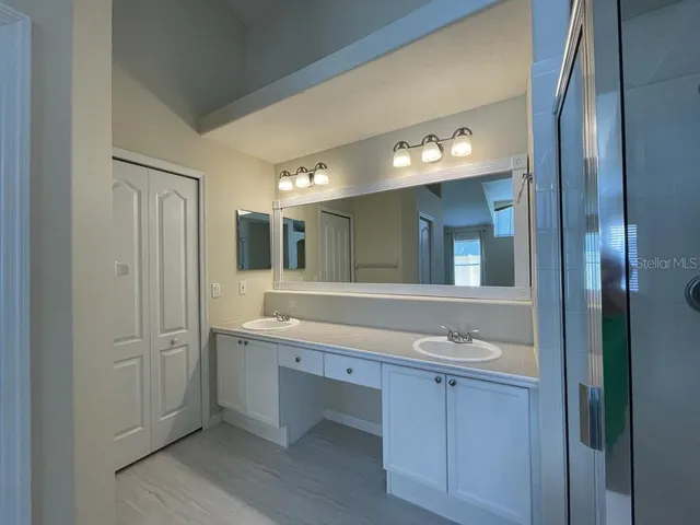 a white bath tub sitting next to a white sink and vanity