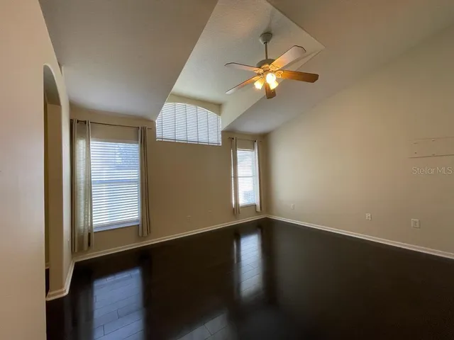 a view of an empty room with window and wooden floor