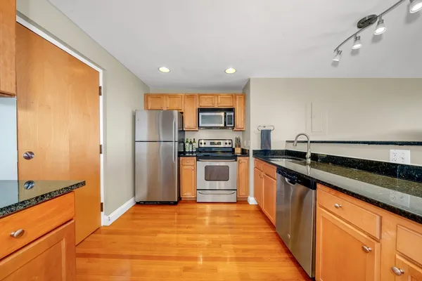 a kitchen with stainless steel appliances granite countertop a refrigerator and a stove top oven