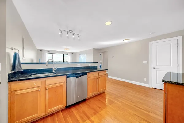 a kitchen with granite countertop a sink and cabinets