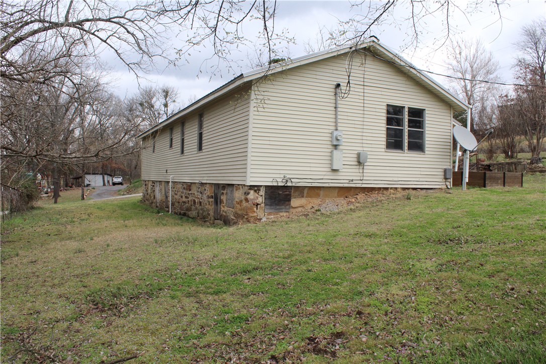 400 Canaan Road Marshall, AR 72650 - Photo 4 of 18 The property features a stone foundation and horizontal siding, with visible windows