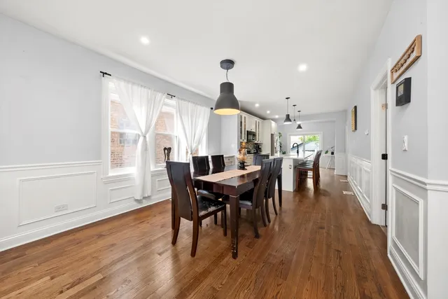 a view of a dining room and livingroom with furniture wooden floor a rug and a chandelier