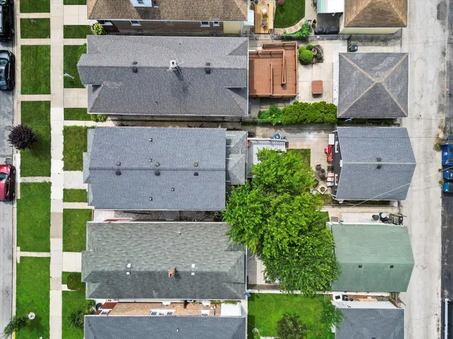 an aerial view of residential houses with outdoor space and parking