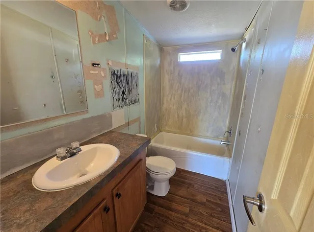 a bathroom with a sink a toilet a mirror and shower