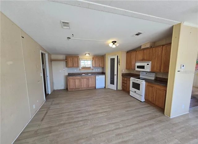 a large kitchen with a refrigerator and a stove top oven