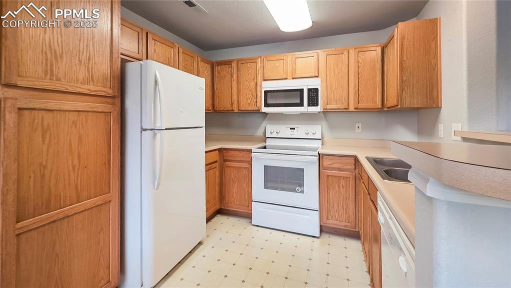 3731 Riviera Grove, Unit 104 Colorado Springs, CO 80922 - Photo 5 of 15 a kitchen with stainless steel appliances a refrigerator sink and microwave