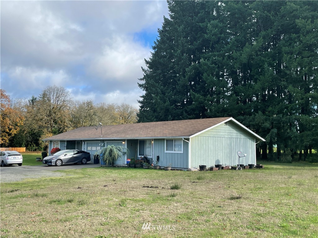 18404 Albany Street Southwest, Unit A & D Rochester, WA 98579 - Photo 1 of 19 a front view of a house with a yard and trees