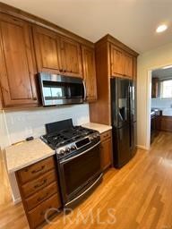 205 Pso De Suenos Redondo Beach, CA 90277 - Photo 23 of 34 a kitchen with granite countertop wooden cabinets stainless steel appliances and a counter space