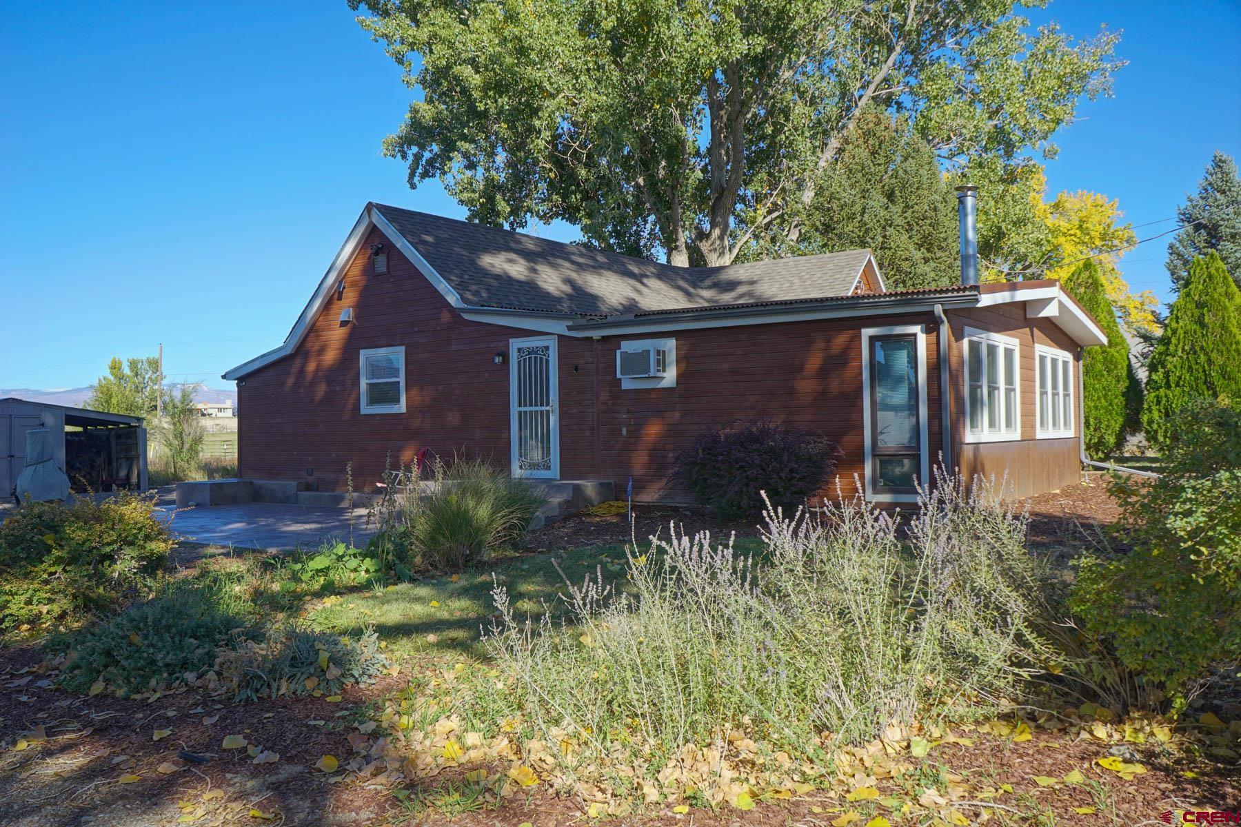 6733 2050th Road Delta, CO 81416 - Photo 22 of 32 a front view of house with yard and trees in the background