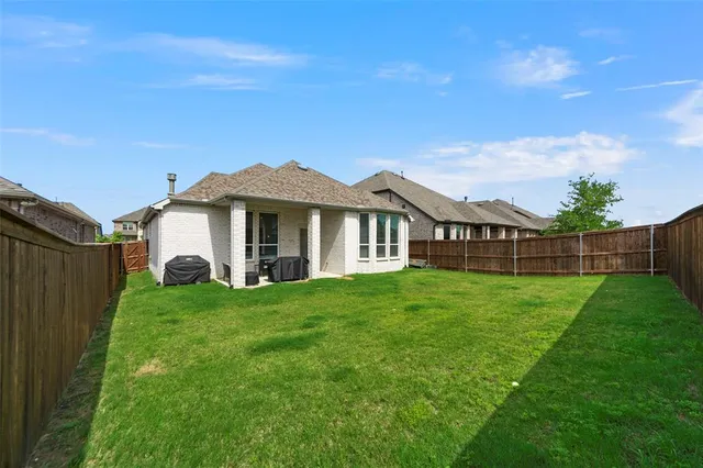 a view of a house with a yard and sitting area