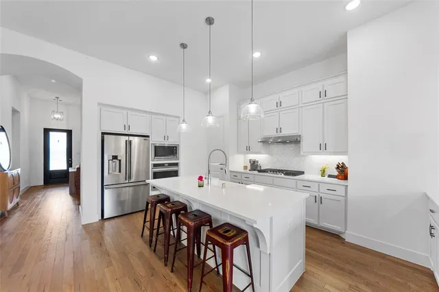 a kitchen with a sink a counter top space stainless steel appliances and cabinets