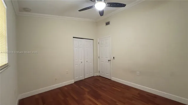 an empty room with wooden floor and closet