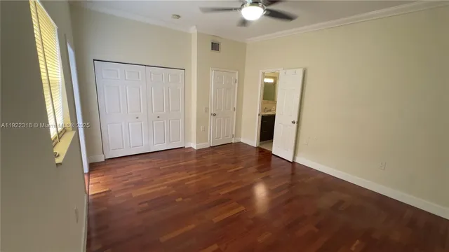 a view of a livingroom with wooden floor and a ceiling fan