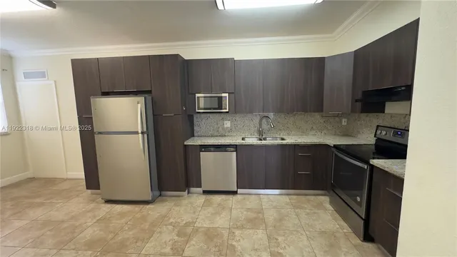 an empty room with stainless steel appliances wooden floor and a window