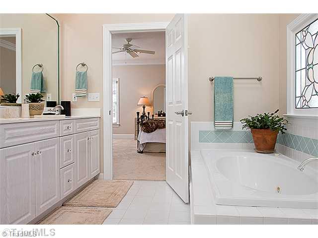1031 Sutton Road Greensboro, NC 27406 - Photo 6 of 16 Master Bath/Spa. Master bathroom offers tile floors and tile surround, double vanities, large walk in closet, jetted tub with beautiful lead glass private window and separate shower