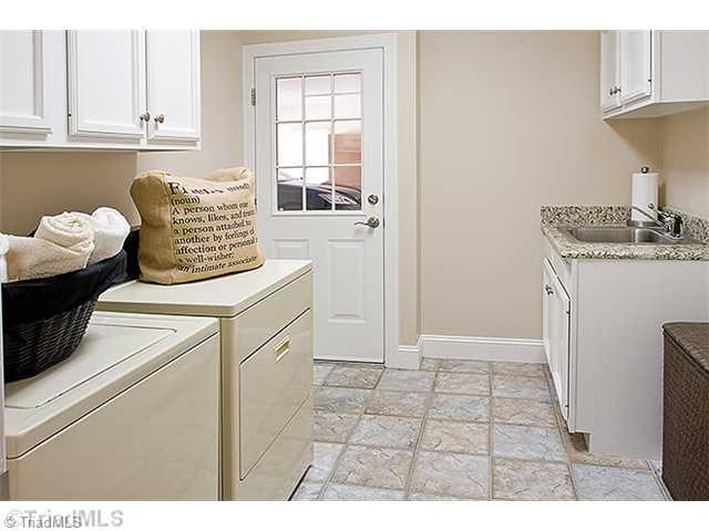 1031 Sutton Road Greensboro, NC 27406 - Photo 9 of 16 Laundry Room. What a laundry room, with tiled floors granite counter top many spacious cabinets for storage!