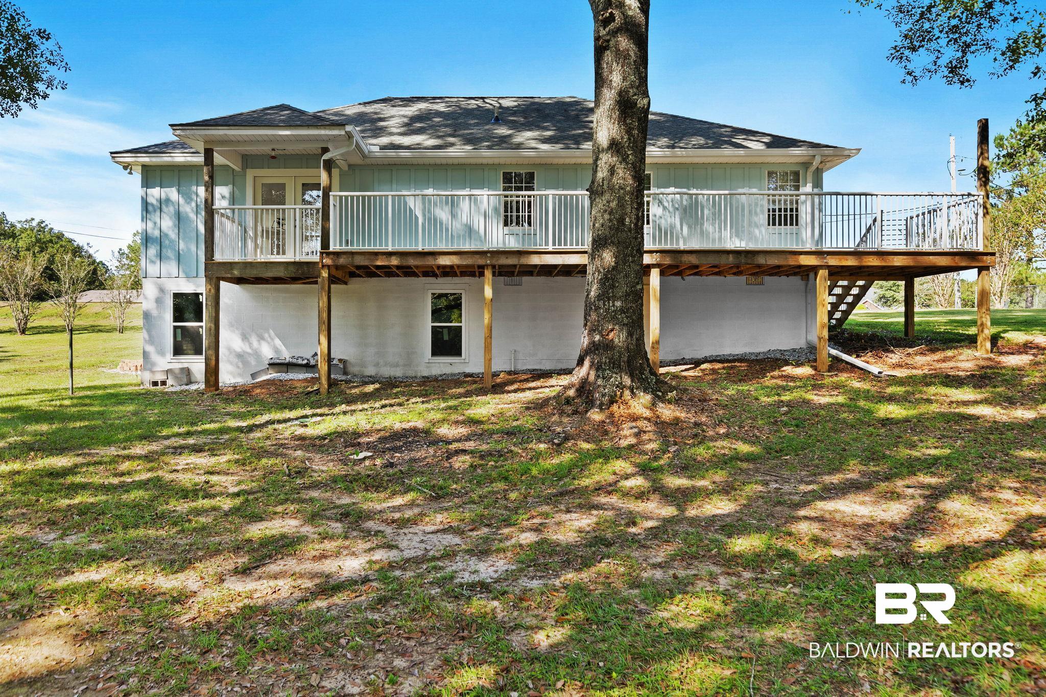 35650 Spring Road North Stapleton, AL 36578 - Photo 56 of 70 Rear view of property featuring a wooden deck, a lawn, roof with shingles.
