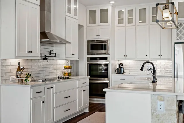 a kitchen with stainless steel appliances a table chairs in it and a microwave
