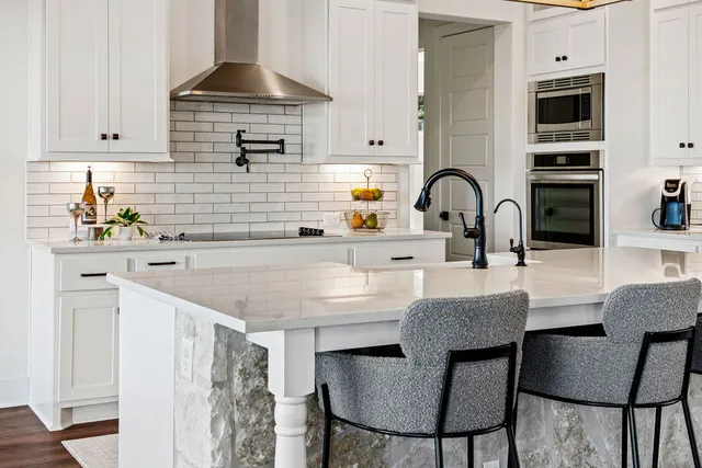 a kitchen with a sink a stove and cabinets