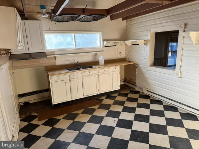 a kitchen with a checkered floor and white cabinets