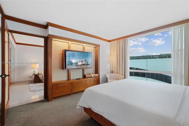 a bedroom with a large bed and a balcony view