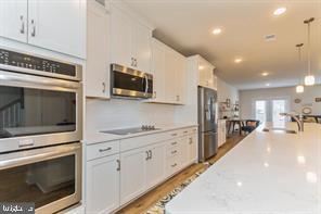 44782 Tiverton Square Ashburn, VA 20147 - Photo 2 of 26 a kitchen with stainless steel appliances kitchen island granite countertop a stove a sink and a microwave