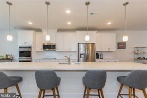 44782 Tiverton Square Ashburn, VA 20147 - Photo 3 of 26 a kitchen with stainless steel appliances granite countertop a sink a stove a refrigerator a kitchen island with chairs and white cabinets