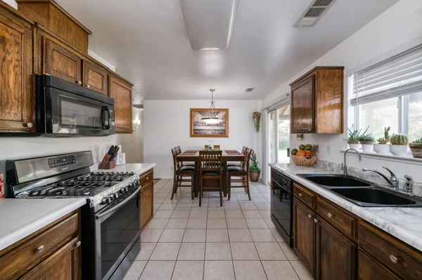 a kitchen with granite countertop a sink cabinets and stainless steel appliances