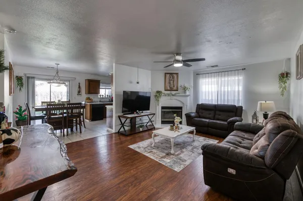 a living room with furniture a flat screen tv and kitchen view