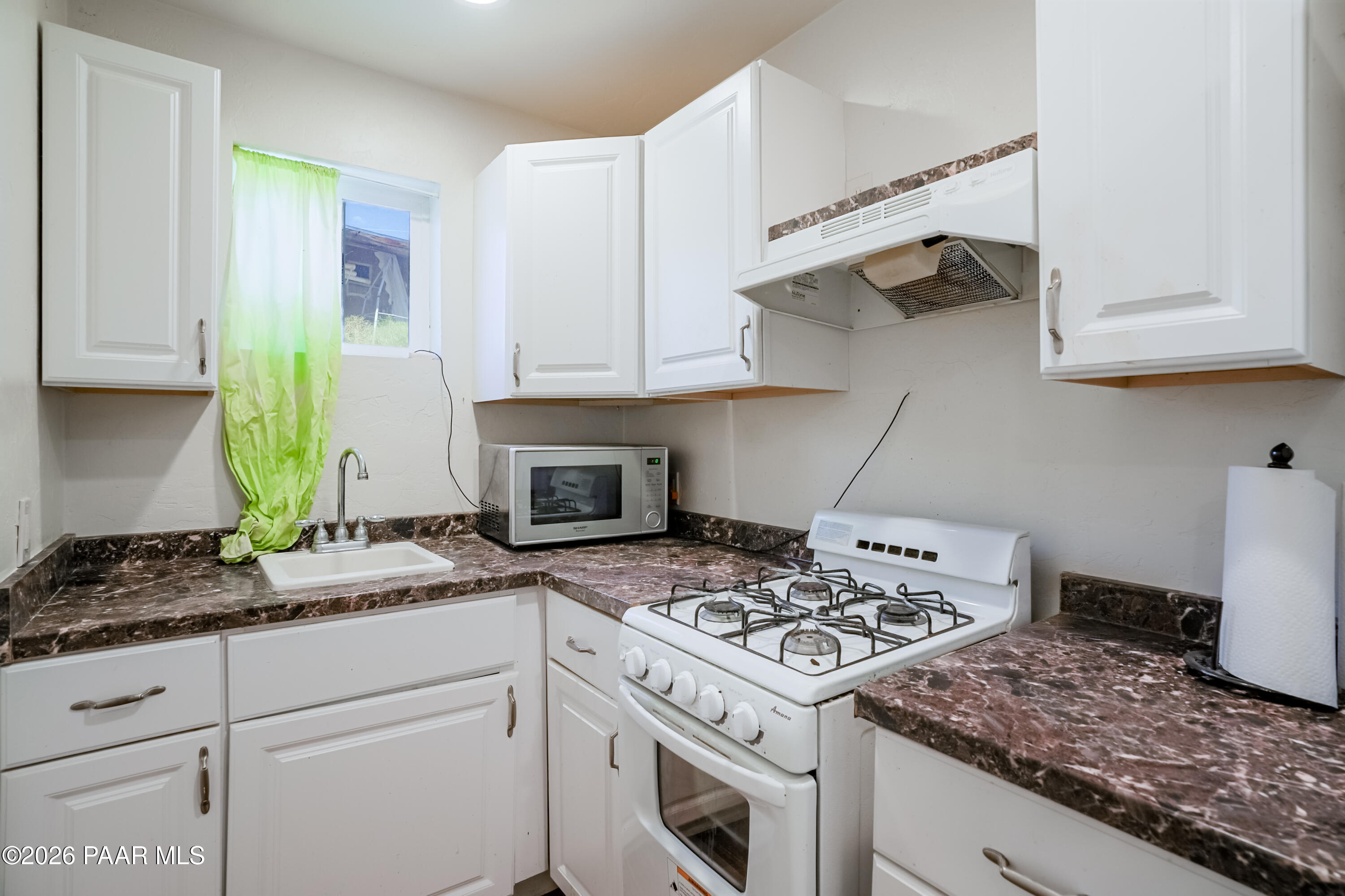 11800 Henderson Road Dewey-Humboldt, AZ 86327 - Photo 32 of 54 a kitchen with stainless steel appliances granite countertop a stove a sink and a white cabinets