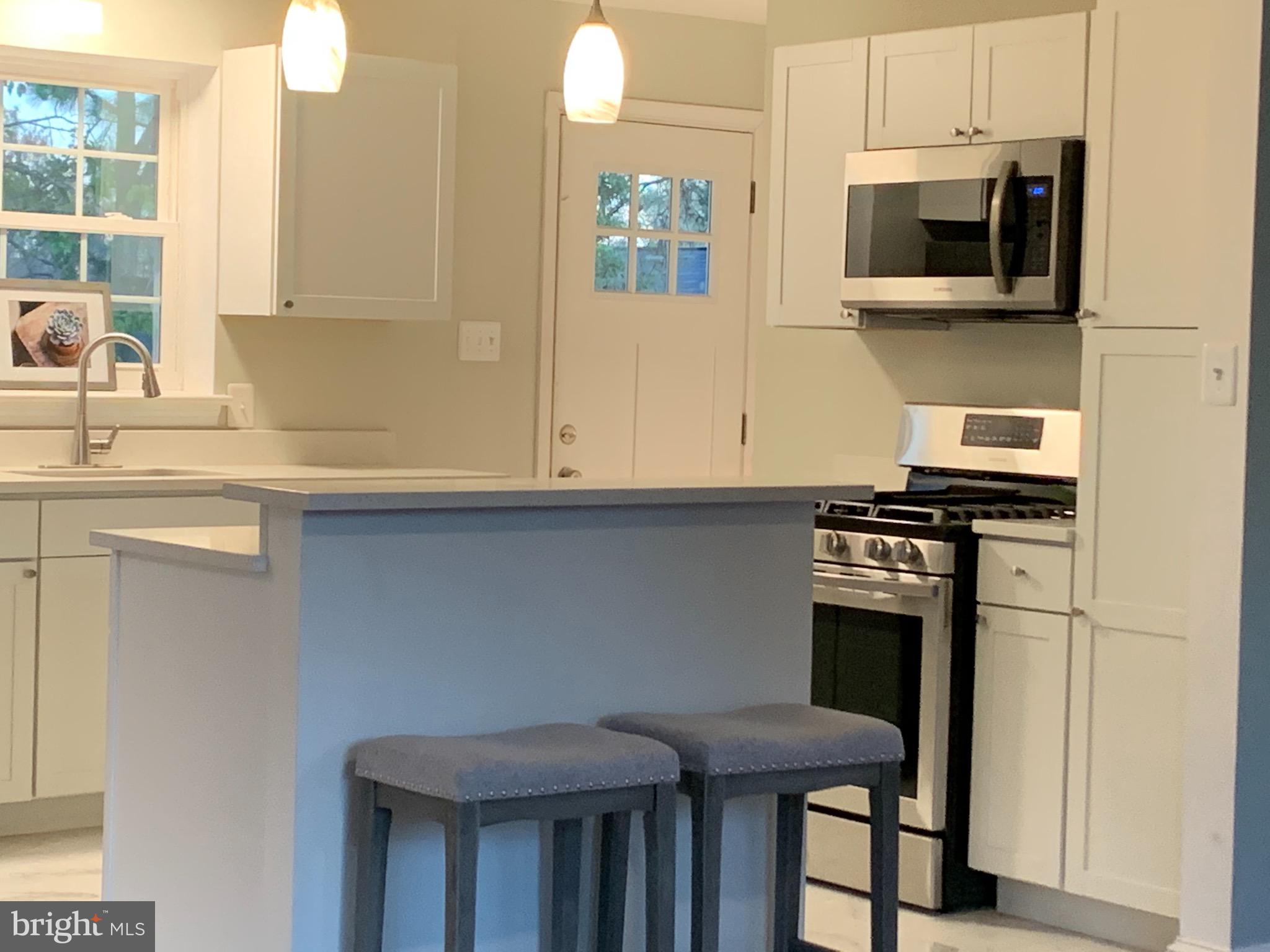 5819 Craig Street Springfield, VA 22150 - Photo 6 of 48 All White Kitchen with Island and Raised Bar.