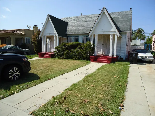 a front view of a house with a garden and yard