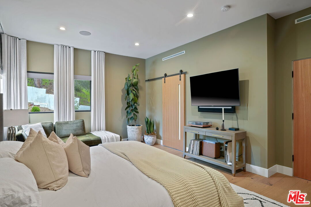 3056 Arrowhead Drive Los Angeles, CA 90068 - Photo 14 of 35 a bedroom with a bed and a flat screen tv